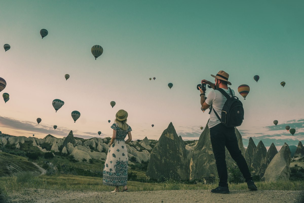 Travel creator filming hot air balloons over the rock formations of Cappadocia