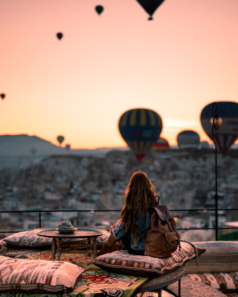 Traveller watching hot air balloons at sunrise in Cappadocia, Turkey