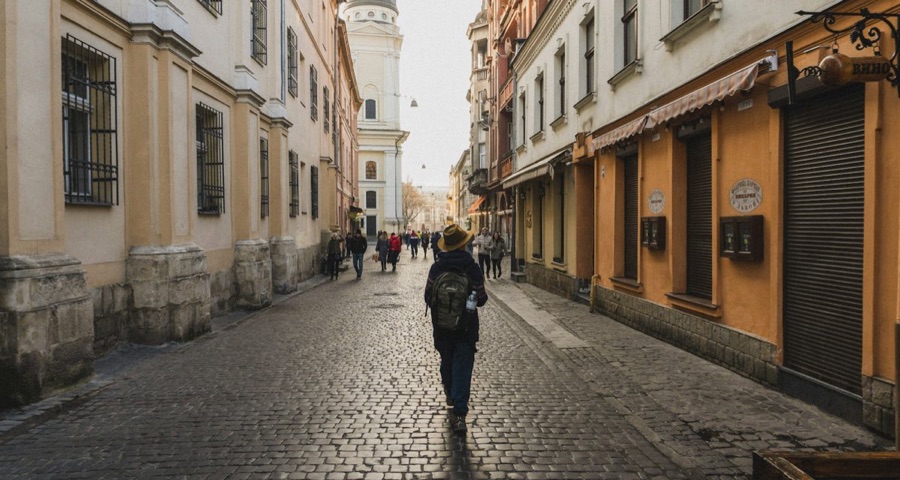Backpacker walking down an old town street